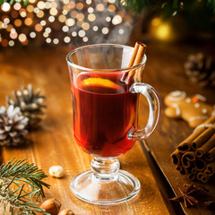 Mulled wine with citrus fruits and cinnamon on a table. Traditional winter hot drink for Christmas Eve party.