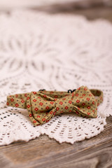 Bow tie and Crochet doily on wooden background