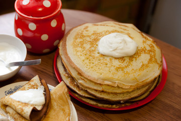 stack of pancakes  on   kitchen table.