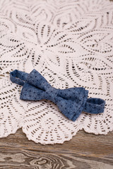 Bow tie and Crochet doily on wooden background