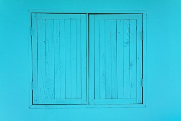 Obraz na płótnie Canvas blue window on blue wall with closed. space for text. Vintage wood plank, Wooden window background