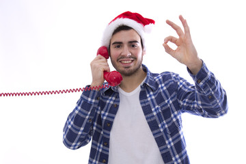 young man with hat of santa claus and landline doing ok symbol