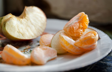 slices of mandarin and apple on a plate close-up