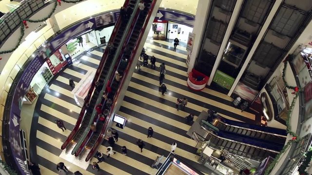 People move up and down the escalators and they move up and down on the elevators at the mall
