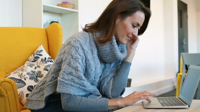 Beautiful young woman using a laptop computer relaxing in a modern coffee shop