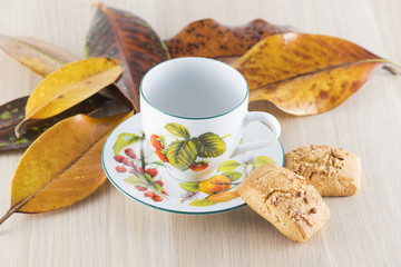 Tea cup, hand-made biscuits and Magnolia Grandiflora leaf