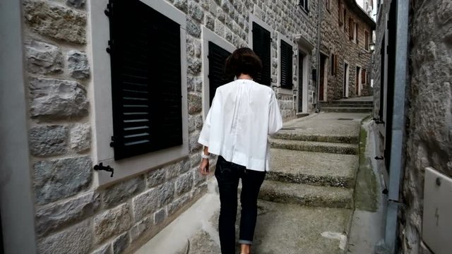 Young woman traveler walking through the city of Kotor, Montenegro