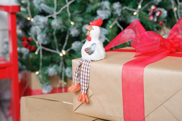 Fototapeta premium the symbol of the new 2017 rooster on the background of Christmas tree and boxes with gifts