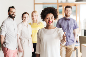 Obraz premium woman making handshake over creative office team