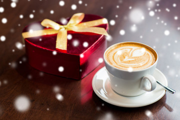close up of gift box and coffee cup on table