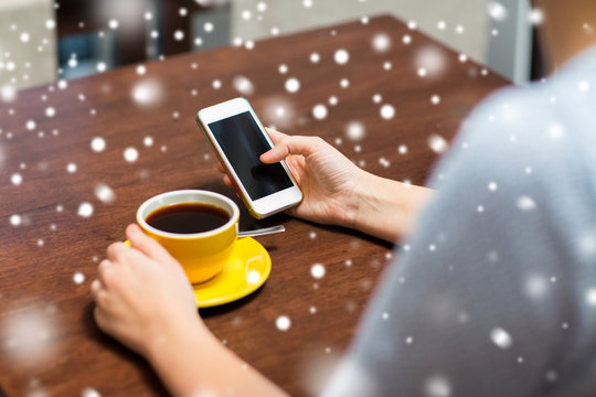 woman with smartphone drinking coffee at cafe