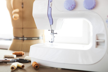 Tailor workshop with white sewing machine, fashion dummy, detail
