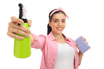 Cheerful woman cleaning with a spray and a sponge