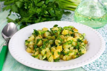 Potato salad on a white plate with fresh herbs