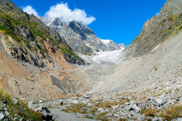 man with backpack is on trail behind glacier chalaady, georgia