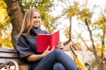 Young woman reading a book in park