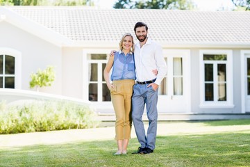 Portrait of happy couple standing with arm around