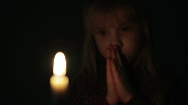 Portrait of a small girl with a candle.