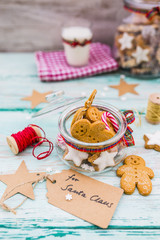 Fototapeta na wymiar Homemade Christmas cookies in a jar and a glass of milk for Santa Claus. 