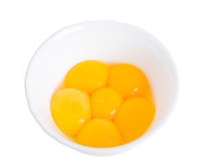 Fresh egg yolks on white bowl.