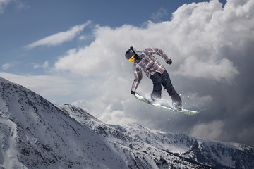 Snowboard rider jumping on mountains. Extreme snowboard freeride sport.