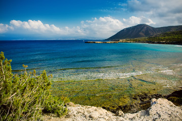 View to the Cyprus island sea coast with blue water and mountain. Akamas cape landscape. Natural seasonal summer vacation background.