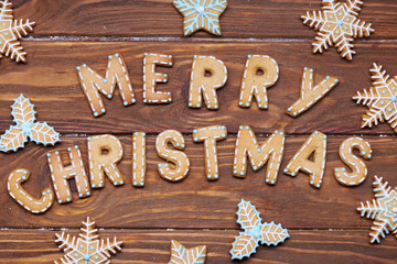 Christmas card. Christmas sign with ginger cookies on a wooden background. Christmas treat decorating. Top view.