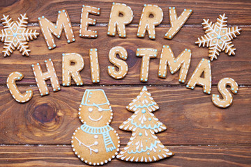 Christmas card. Christmas sign with ginger cookies on a wooden background. Christmas treat decorating. Top view.