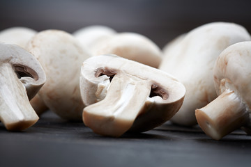 Fresh champignon mushrooms on dark background