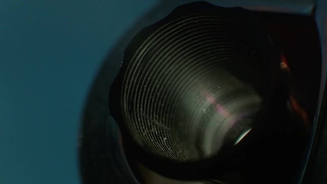 Film projector close up, projector lens and light. Digital film projector lens in action. Macro shot, slow motion