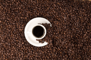 coffee beans topview fullscreen with coffee cup and spilled beans on the saucer