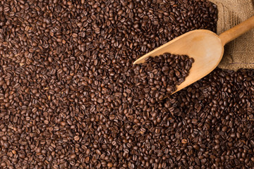coffee beans fullscreen topview with a serving spoon and burlac sac in the corner