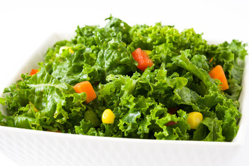 Kale salad in bowl with carrot, pepper and sweet corn isolated on white background   © chandlervid85
