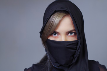 Headshot samurai woman dressed in black with matching veil covering face, facing camera, ninja concept