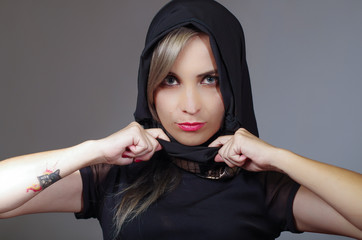 Samurai woman dressed in black, holding matching veil adjusting using hand, facing camera, ninja concept