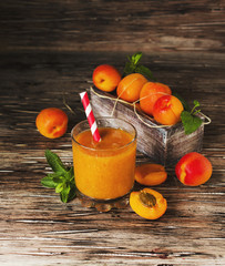 Fresh apricot juice in glass on wooden table, selective focus