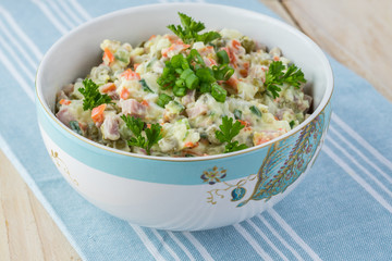 Traditional russian olivier salad with ham vegetables.