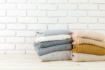 Stack of white cozy knitted sweaters
