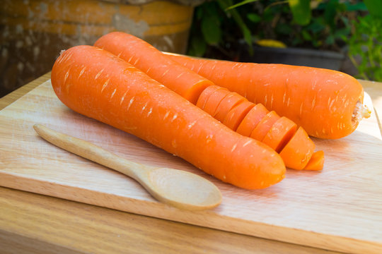 fresh carrots on wooden board
