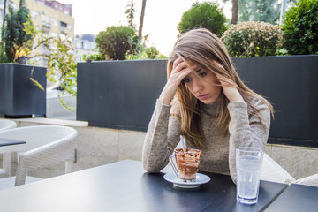 Close up of sad young woman deep in thought outdoors. 