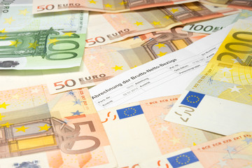 Eine Gehaltsabrechnung und viele Euro Geldscheine