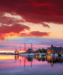 Fototapeta na wymiar Bergen harbor with boats against colorful sunset in Norway, UNESCO World Heritage Site