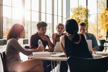 Young students studying around a table in library