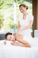 Obraz na płótnie Canvas Female masseur massaging woman at spa