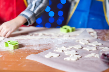 Fototapeta premium hands of a child who is preparing cookies in the kitchen with flour and dough