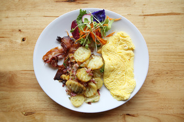 A delicious home style breakfast with crispy bacon, eggs omelett