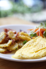 A delicious home style breakfast with crispy bacon, eggs omelett
