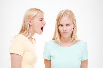 Two young ladies swear over white background