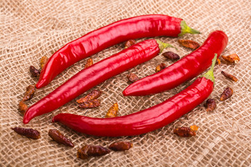 The pods of red hot pepper and chili peperoncini on burlap background