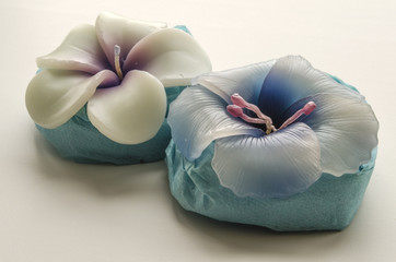 Two decorative candles in the shape of flowers on a light background
